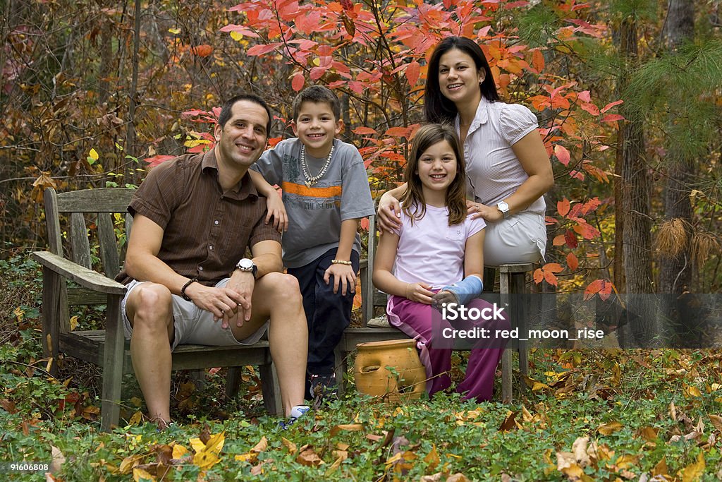 FAMIGLIA FELICE in posa in un giardino autunnale panorama - Foto stock royalty-free di Famiglia