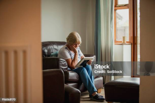 Senior Woman Looking At Photo Frame Stock Photo - Download Image Now - Death, Sadness, Photography