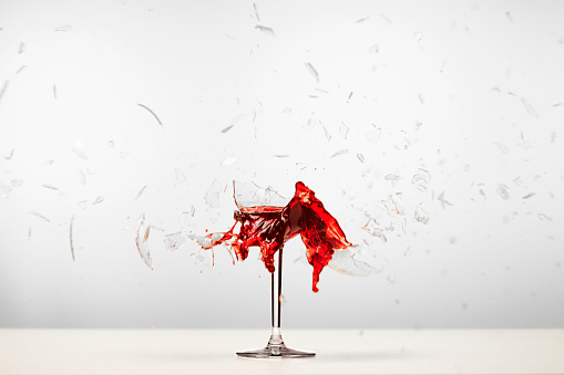 Red wine glass explodes.  glass and wine explodes in the picture