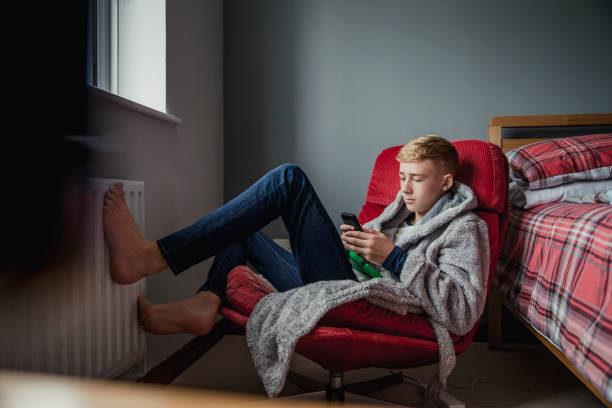 Teenage Boy Relaxing in his Bedroom A teenage boy uses his phone and relaxes in his bedroom. one teenage boy only stock pictures, royalty-free photos & images