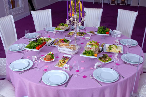 istock The elegant dinner table. Wedding table decorated with candles, served with cutlery and crockery and covered with a tablecloth . Salad . Pink tablecloth . White chairs . White wedding table. A table decorated with balloons. 916068908