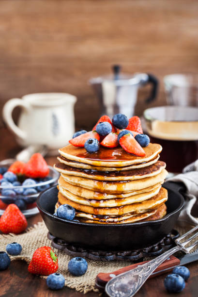 istock Stack of freshly prepared banana  pancakes with fresh berries and maple syrup 916071844