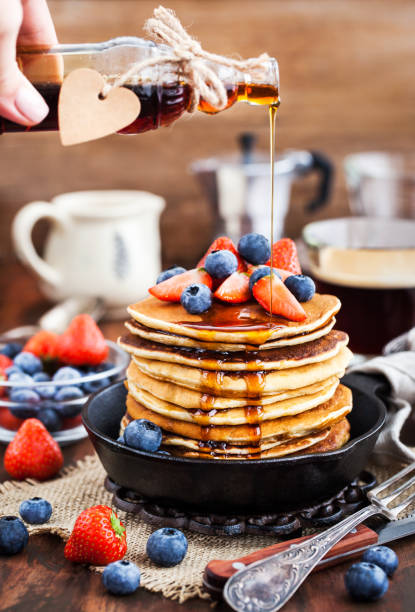 istock Stack of freshly prepared banana  pancakes with fresh berries and maple syrup 916071856