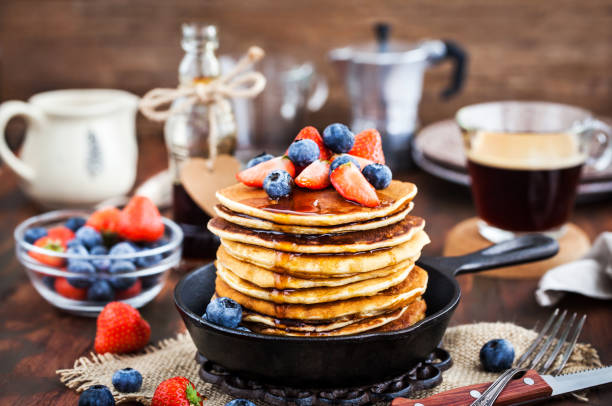 istock Stack of freshly prepared banana  pancakes with fresh berries and maple syrup 916071862