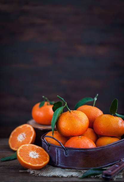 istock Fresh tangerines with leaves on  wooden table 916071868