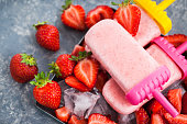 Delicious strawberry popsicles ice cream with ice and  fresh berries around