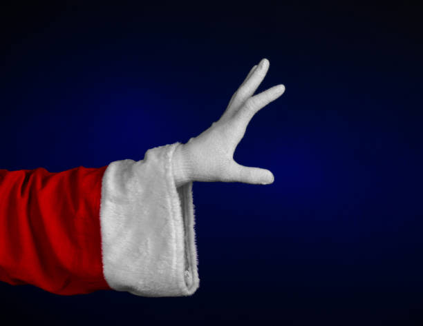 istock Santa Claus theme: Santa's hand showing gesture on a dark blue background 916072164