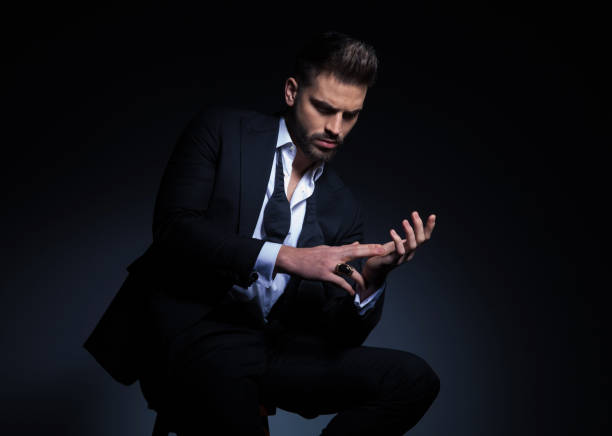 istock elegant young man in tuxedo playing with his hands 916072652