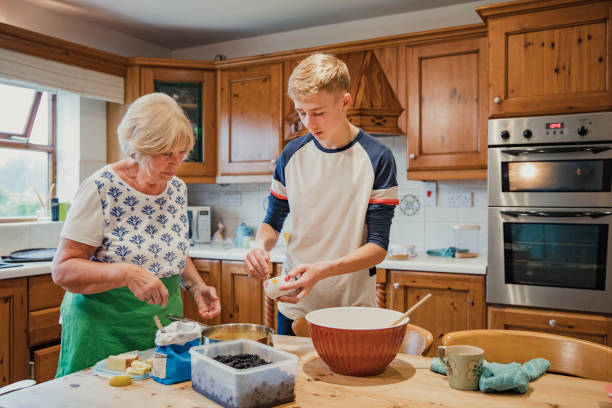 A senior woman cooks with her grandson.