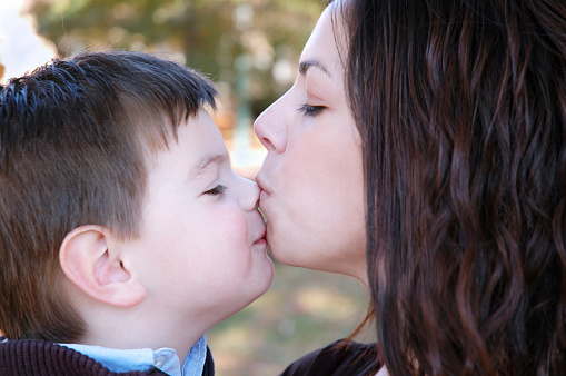 Мальчик целует маму