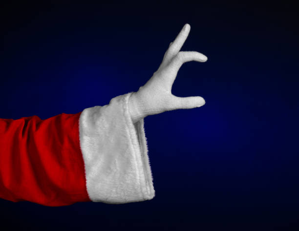 istock Santa Claus theme: Santa's hand showing gesture on a dark blue background 916076840
