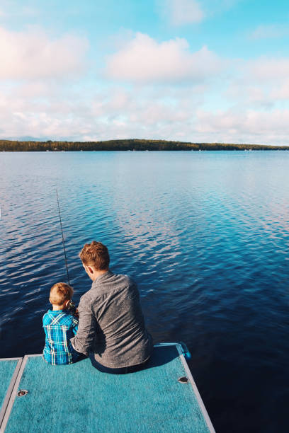 Father and son disagree on the size of a fish; excited boy and skeptical father; digitally cross-processed
