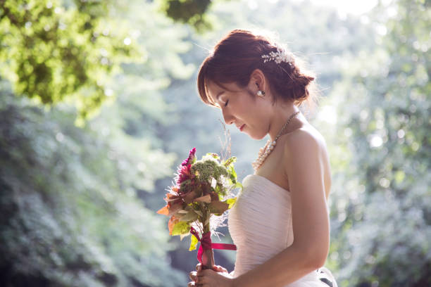 noiva segurando um buquê no parque - welcome sign greeting congratulating wedding - fotografias e filmes do acervo