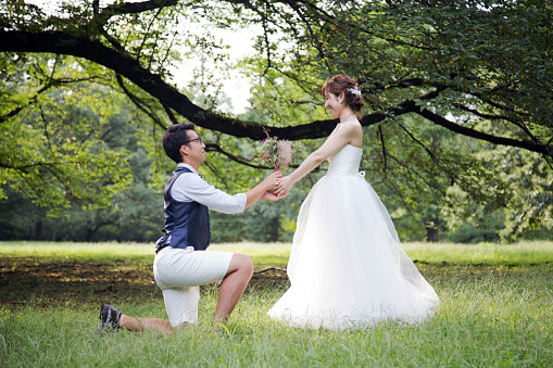 Japanese couple wearing wedding costumes relaxed in the park.