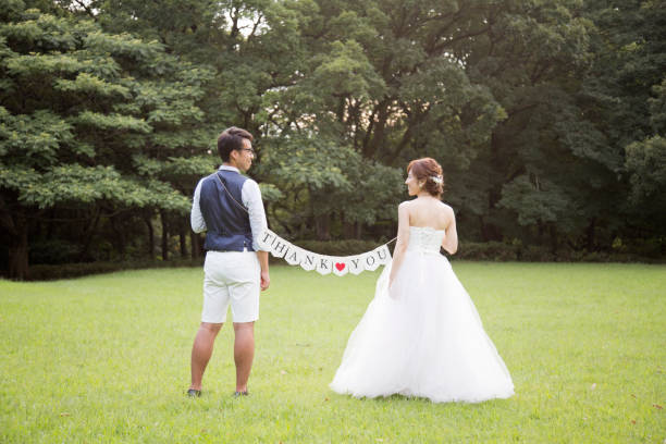 noiva e noivo, vestindo trajes de casamento segurando bandeiras com a mensagem que dizem "obrigado" no parque - welcome sign greeting congratulating wedding - fotografias e filmes do acervo