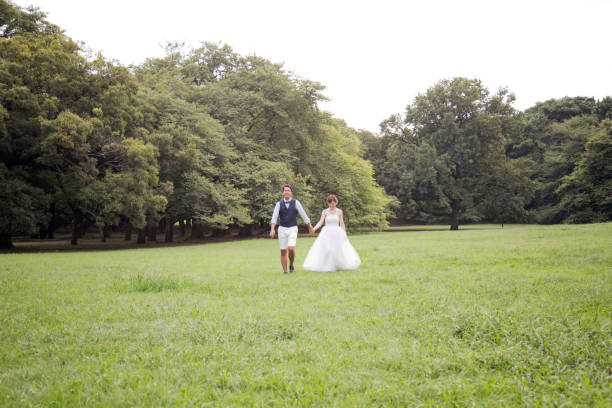 noiva e noivo vestindo trajes de casamento andando no parque - welcome sign greeting congratulating wedding - fotografias e filmes do acervo