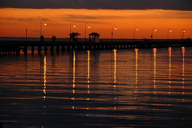 Pôr do sol no cais de St Kilda Beach - foto de acervo