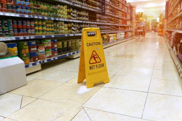 close up Yellow sign - caution. Wet floor is in the supermarket against the background of blurry products standing on the shelves Wet stock pictures, royalty-free photos & images