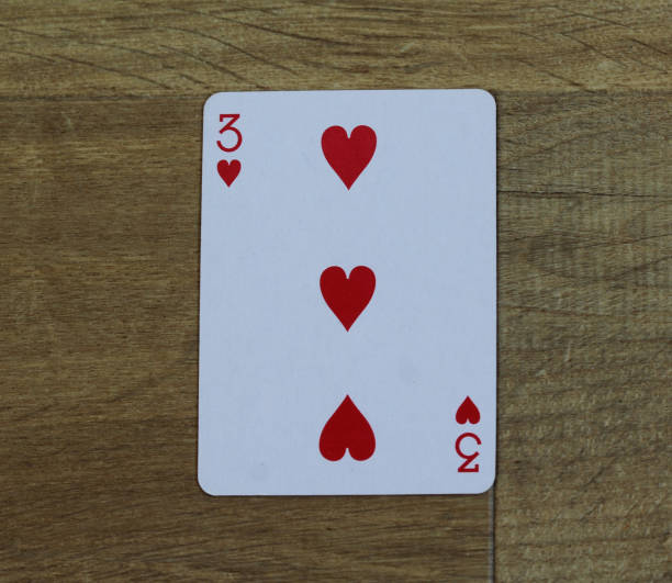 istock Poker card heart three on wooden background 916084350