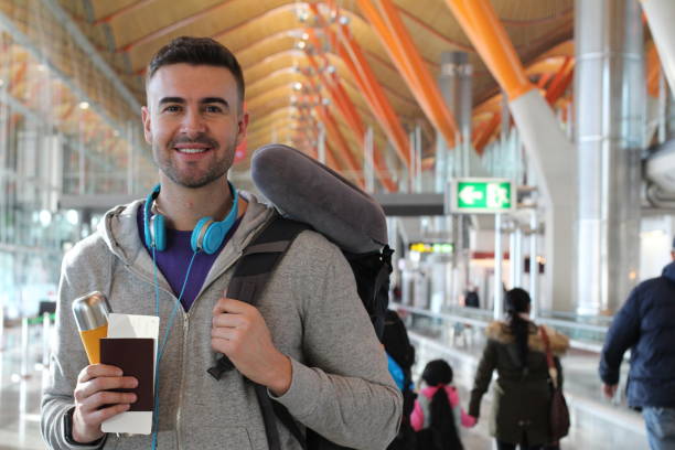 istock Man smiling in crowded airport 916085154
