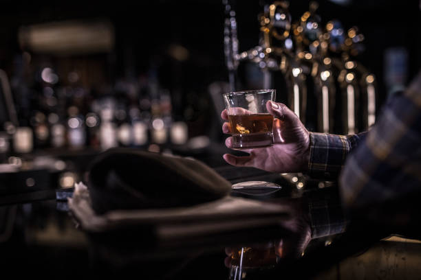 verre de whisky alcoolique dans la main un vieil homme - shallow depth of focus photos et images de collection