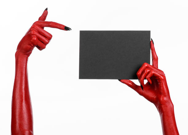 istock Halloween theme: Red devil hand with black nails holding a blank black card on a white background 916092266