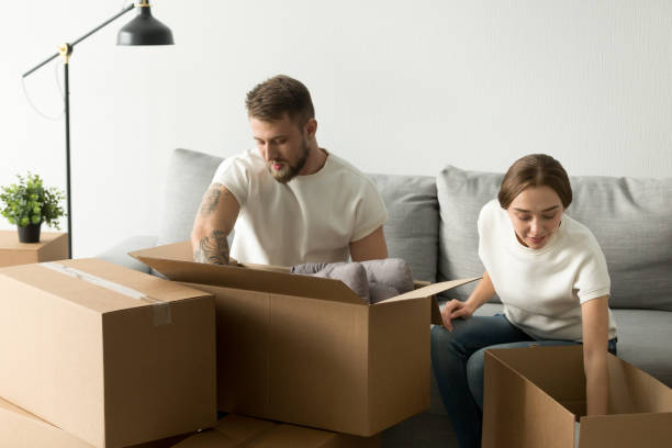 istock Man and woman packing unpacking boxes together, moving day conce 916092460
