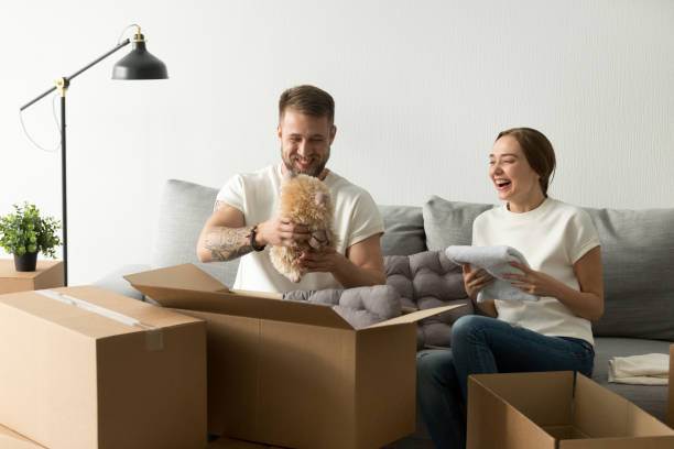 istock Laughing young couple having fun packing boxes in new home 916092478