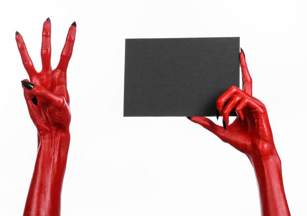 istock Halloween theme: Red devil hand with black nails holding a blank black card on a white background 916096774