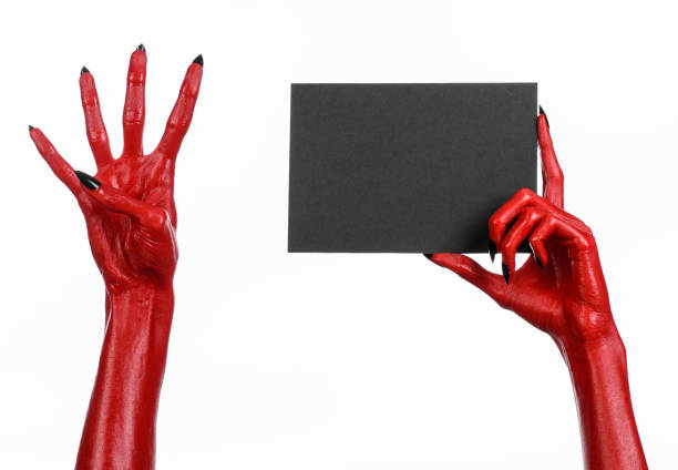 istock Halloween theme: Red devil hand with black nails holding a blank black card on a white background 916102994
