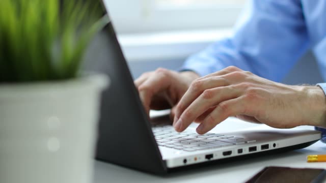 businessman typing on laptop keyboard working in office