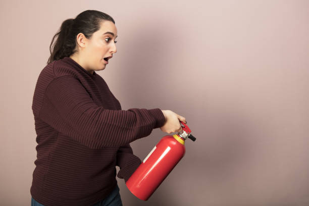 istock Woman holding a fire extinguisher 916113030