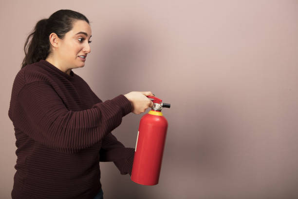 istock Woman holding a fire extinguisher 916113040