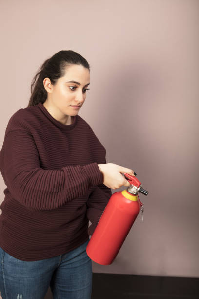 istock Determined woman holding a red fire extinguisher 916113046