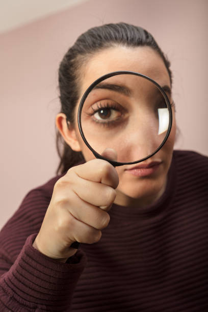 istock Woman looking through magnifying glass 916115770