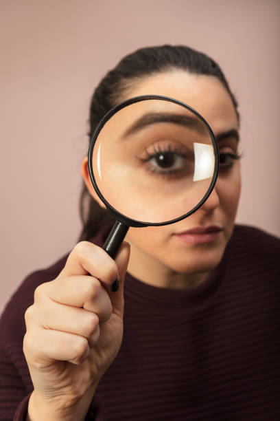 istock Woman looking through magnifying glass 916115774