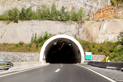 Scenic view on entrance to the tunnel and highway road leading through in Croatia, Europe / Transport and traffic infrastructure / Signs and signaling.
