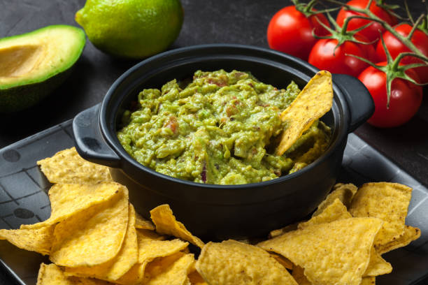 Bowl of guacamole with corn chips stock photo