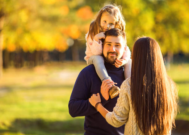 istock Family playing in autumn park having fun at sunset 916120742
