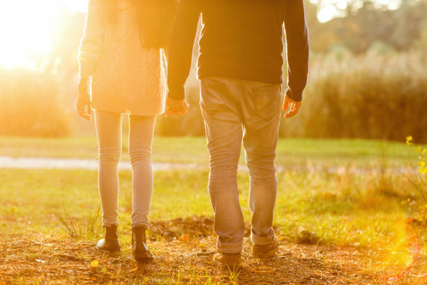 young couple in love outdoor at sunset - silhouette kissing park sunset imagens e fotografias de stock