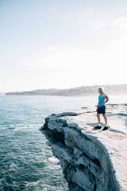 istock Gray hair senior runner looking at the ocean 916121820