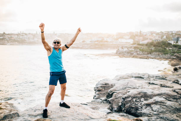 istock Senior runner raises arms after run 916124770