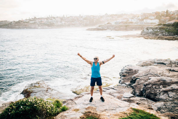 istock Senior runner raises arms after run 916124834