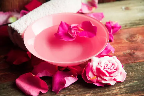 rose water - flower petals rose, towel, concept of care and beauty treatments in Spa