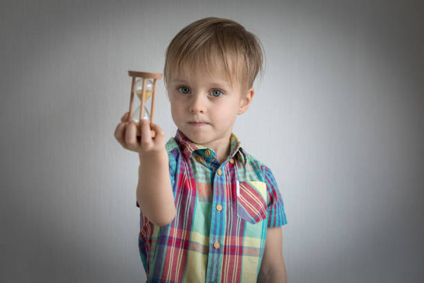 little boy with a sand clock in his hand - clock face clock deadline human hand imagens e fotografias de stock