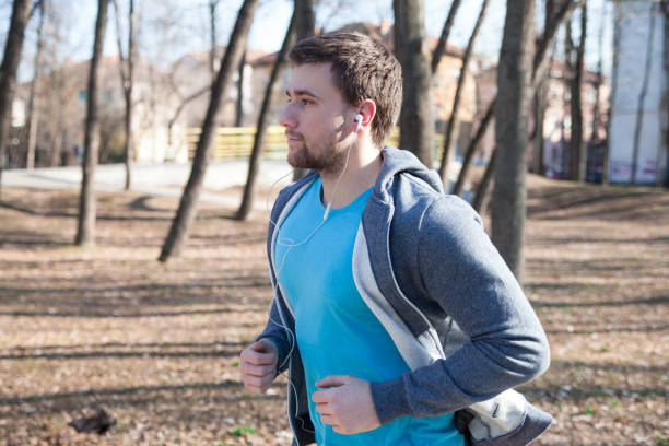 istock Young man running during sunny morning on park 916145090