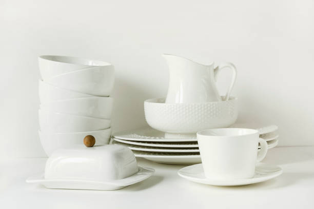 istock White tableware for serving. Crockery,dish, utensils and other different white stuff on white table-top. Kitchen still life as background. Copy space. 916145404