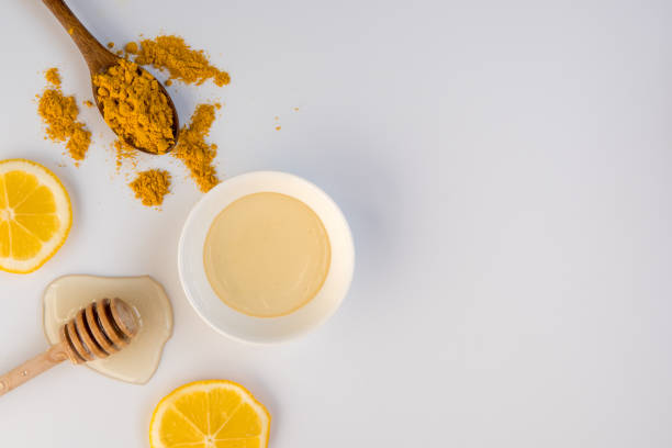 istock Honey stick, spoon with turmeric and lemon slices top view, copy space 916150684