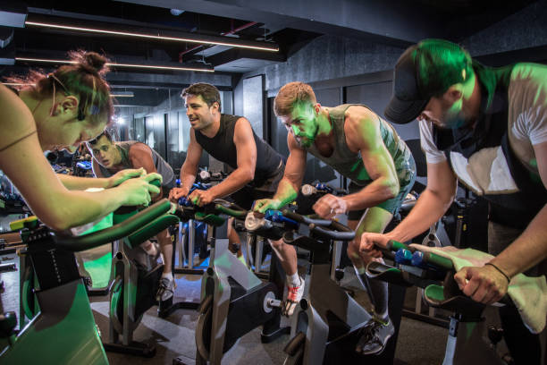 group of sporty people cycling at gym. - spinning instructor exercising gym imagens e fotografias de stock