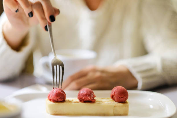 istock Girl eats cheesecake dessert with mint on plate. 916151392